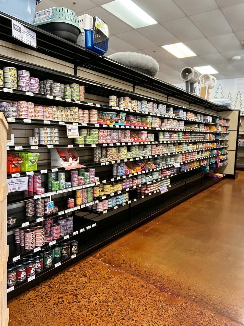 A long wall of canned cat and dog food