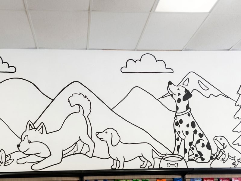 A line-drawing mural of dogs, a dalmatian and a lizard among the mountains
