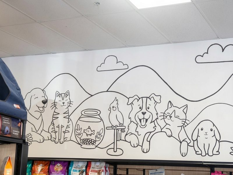 The line-drawing mural above the food shelves at Tigard Pet Supply: a dog, a cat, a fishbowl, a bird, a puppy, a kitten and a bunny in front of the mountains